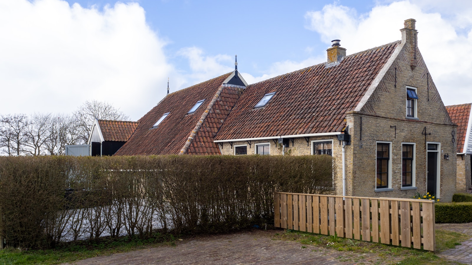 brown brick house near green grass field during daytime