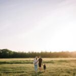 man and woman walking on green grass field during daytime